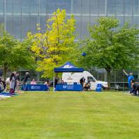 Wide view of participants throwing bags during cornhole games